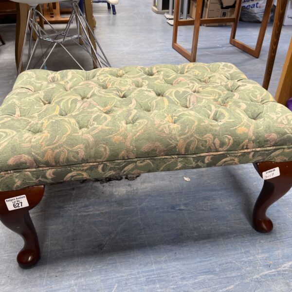 Vintage green floral footstool with turned wooden legs.