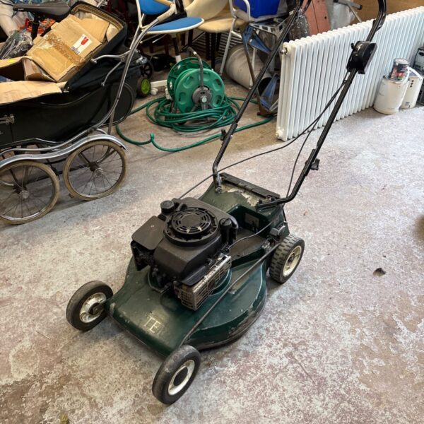 Green Hatter petrol lawn mower in a garden setting.