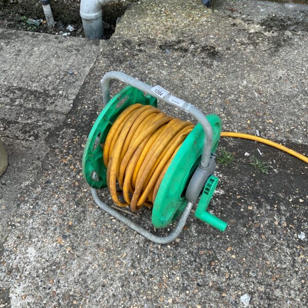 Green plastic hose reel with yellow hose wound around it.