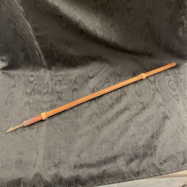 Vintage hand fishing spear on dark background.