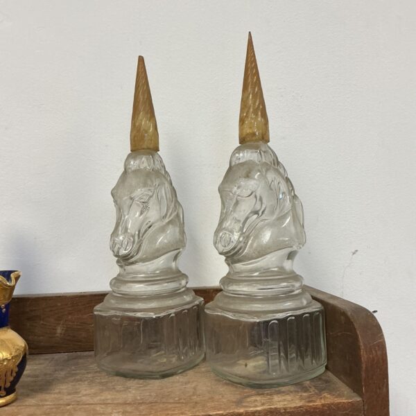 Pair of vintage Harrods glass unicorn decanters on display.