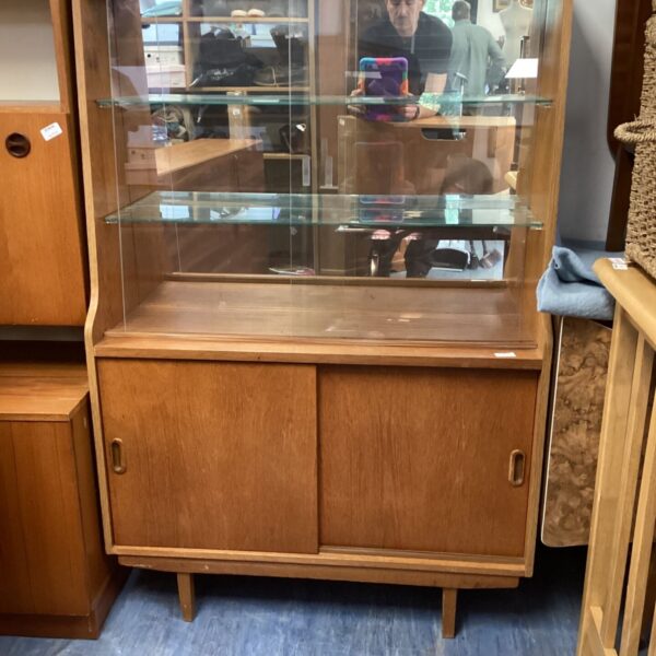 Mid-century modern teak display cabinet with sliding glass doors.