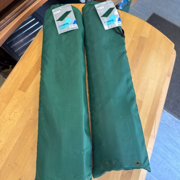 Two folded Hi Gear single camp beds ready for outdoor adventures.