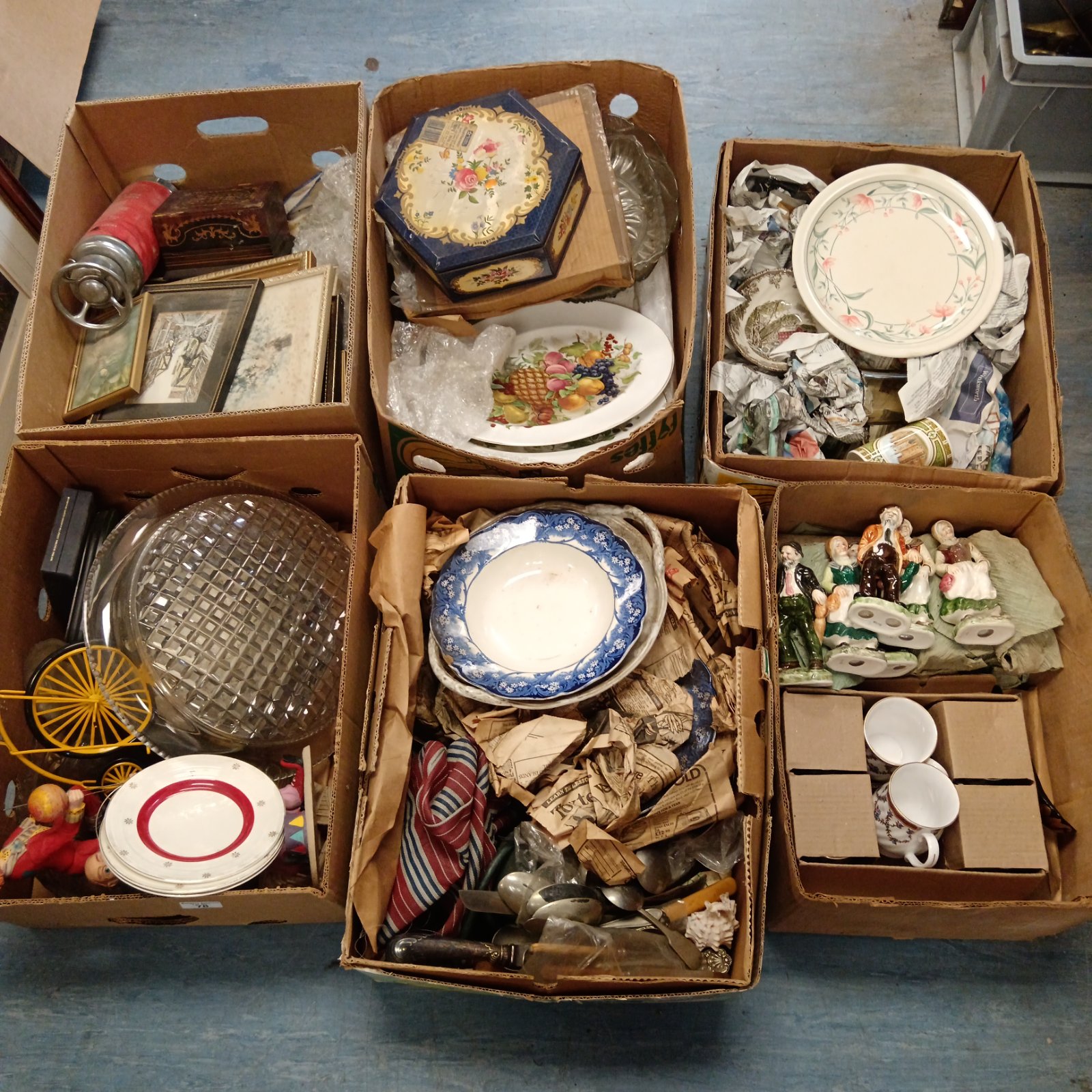 House clearance lot with mixed vintage items and collectibles in cardboard boxes.