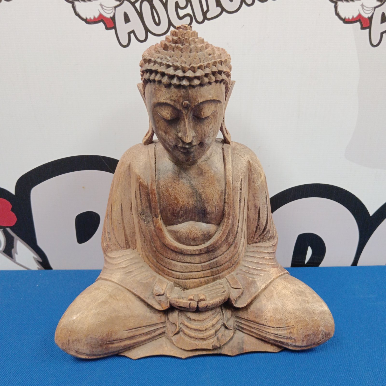 Vintage Indonesian wooden Buddha statue in meditative pose.
