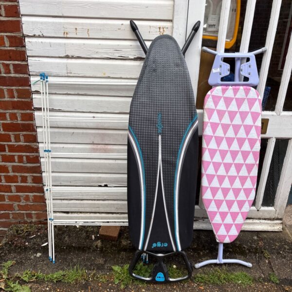 Two ironing boards and a clothes rack for laundry.
