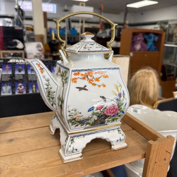 Vintage Japanese porcelain teapot with floral design and stand.