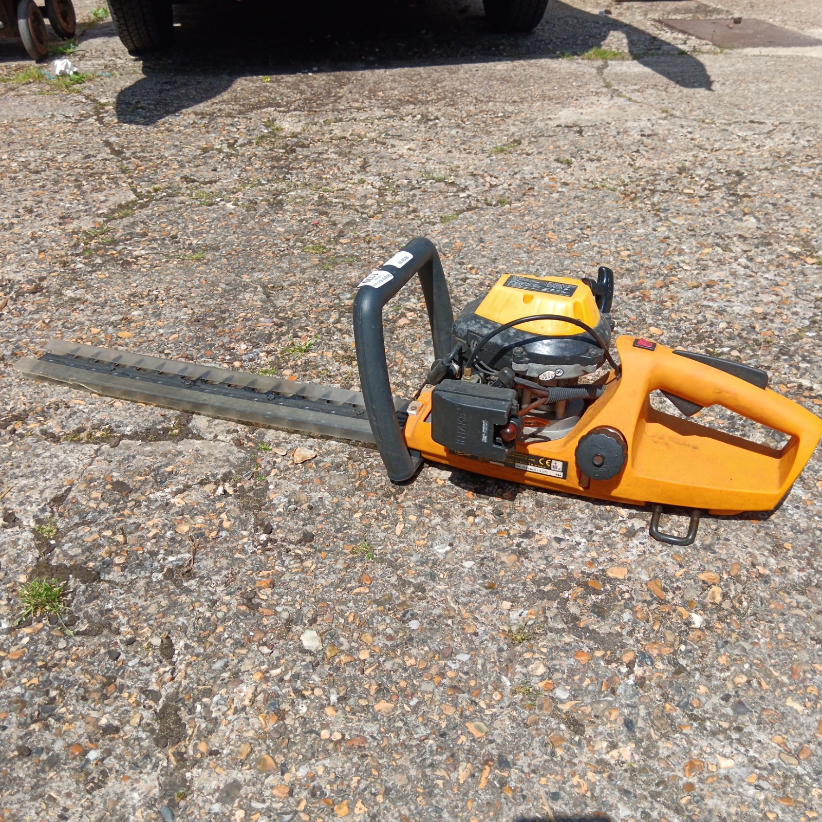 JCB petrol hedge cutter showing blade and engine housing.