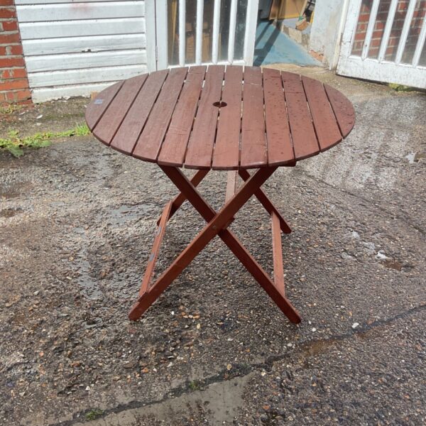 John Lewis teak folding table in a garden setting.