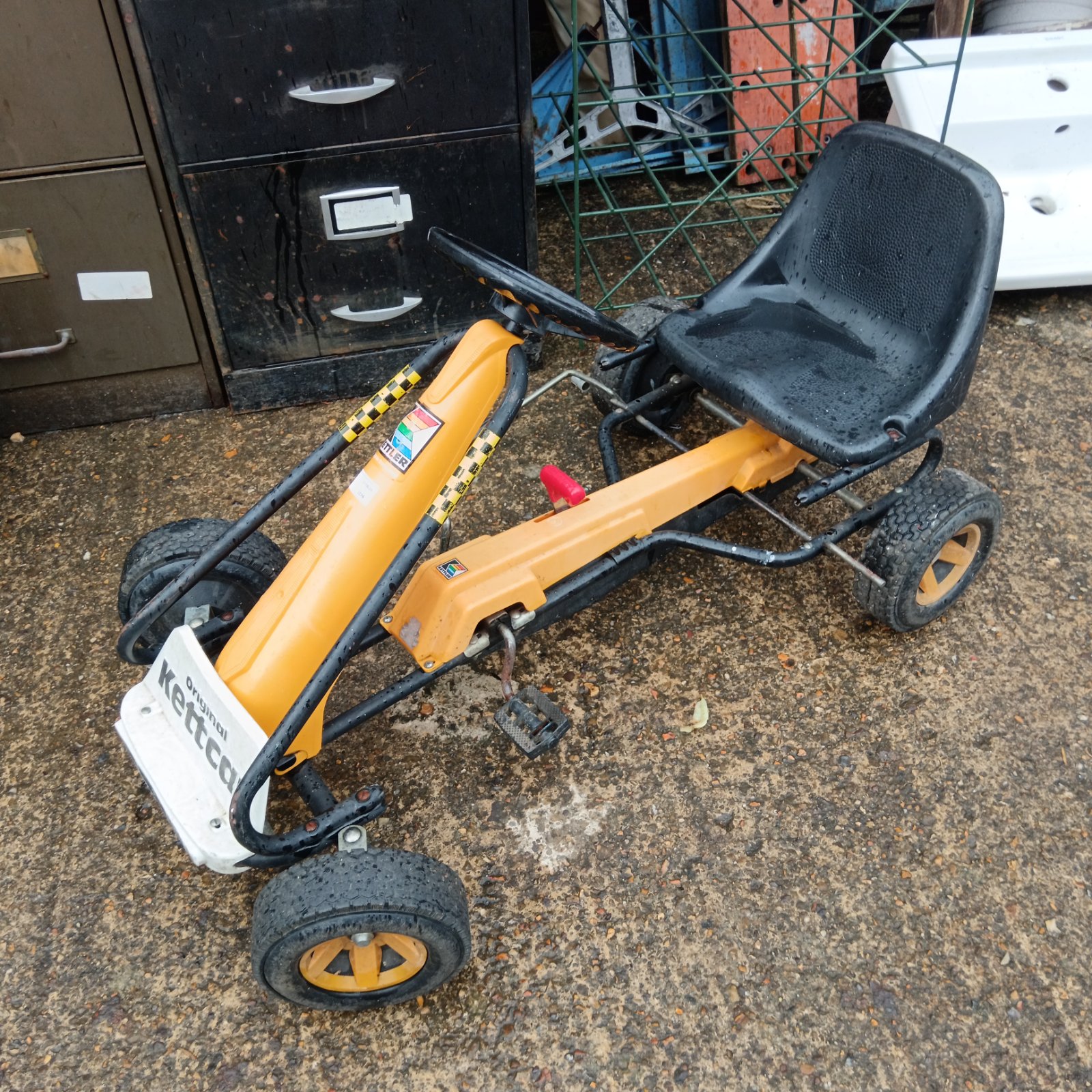 Vintage yellow Ketcar pedal car, a classic children's ride-on toy.
