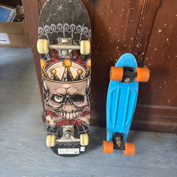 Kids skateboards lot featuring skull graphic and penny board.