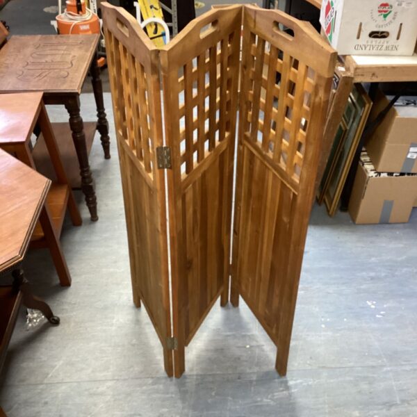 Wooden lattice privacy screen with a repeating pattern.