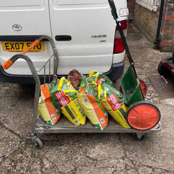 Job lot of lawn feed and seed with a garden trolley.