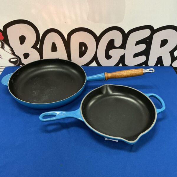 Vibrant blue Le Creuset frying pan with wooden handle.
