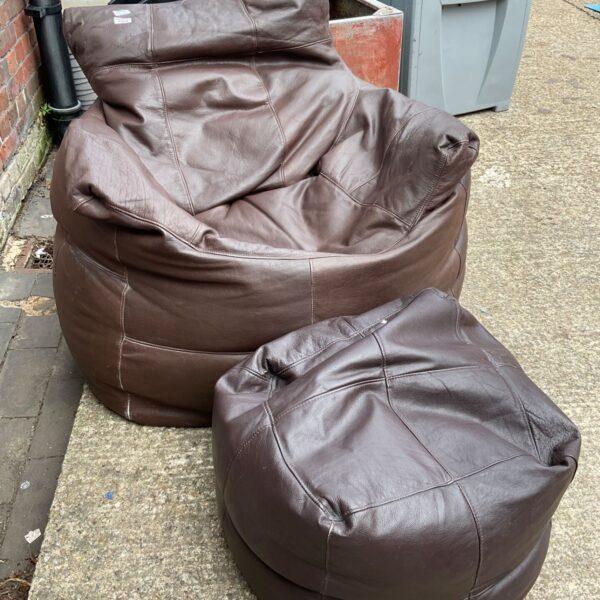 Dark brown leather bean bag chair with footrest.