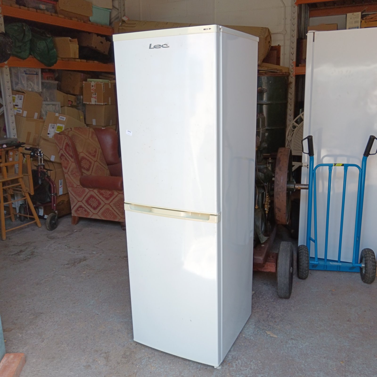 White LEC fridge freezer in a workshop setting.