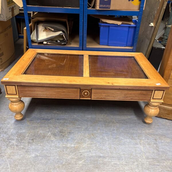 Light oak coffee table with glass top, vintage style.