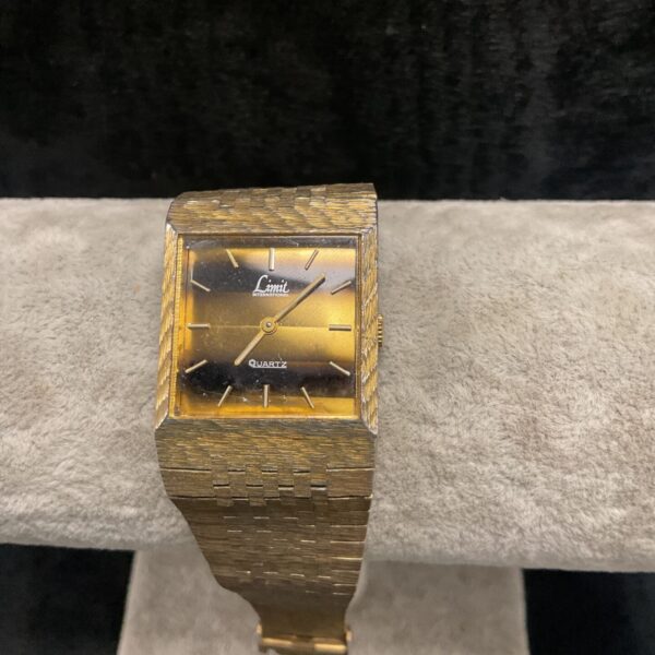 Vintage Limit International watch with tiger eye dial and gold strap.