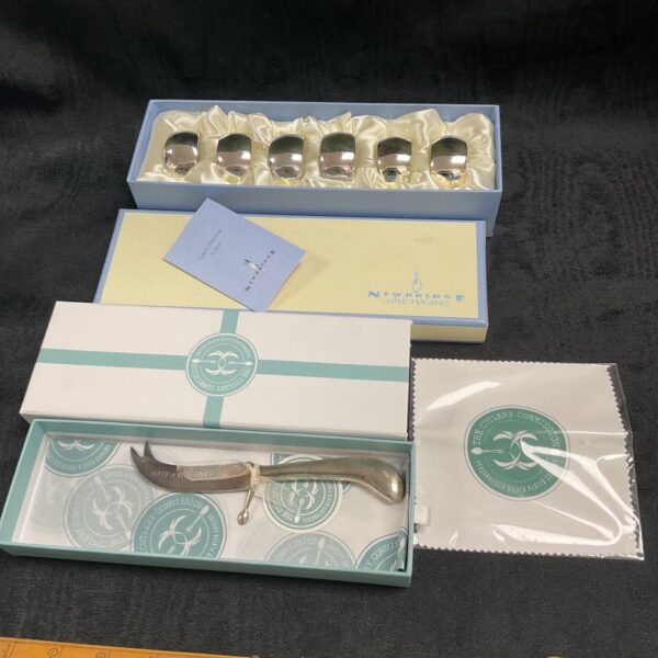 As new set of silver plate napkin rings and silver plate cheese knife in boxes
