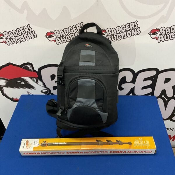 Black Lowepro camera bag with a Cobra monopod visible inside.