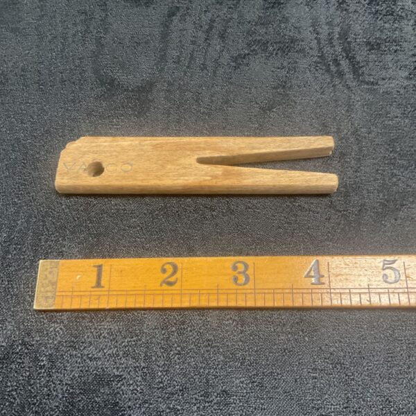 WWII Luftwaffe clothes peg next to a ruler for scale.