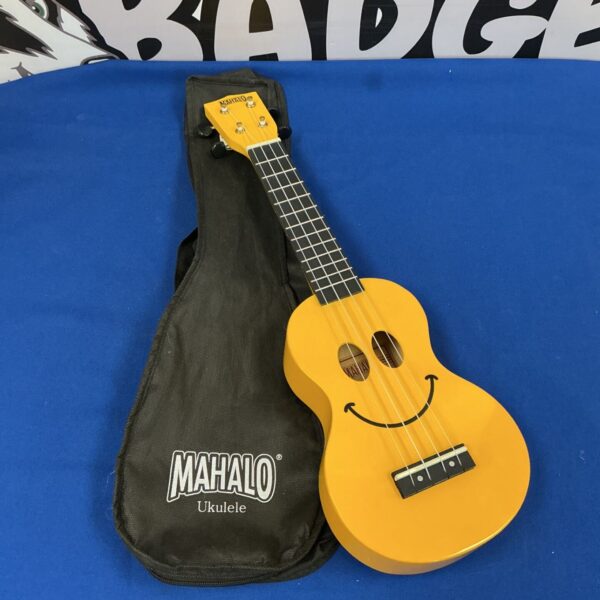 Yellow Mahalo ukulele with a smiley face, vintage musical instrument.
