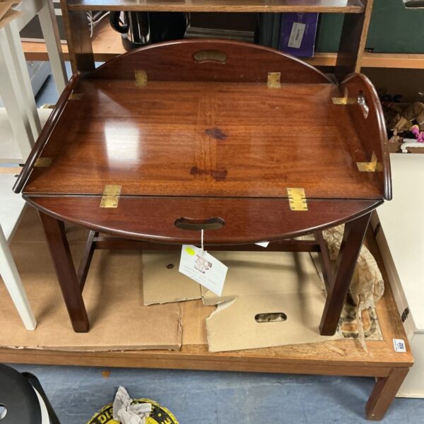 Antique mahogany oval butlers table on stand, side view.