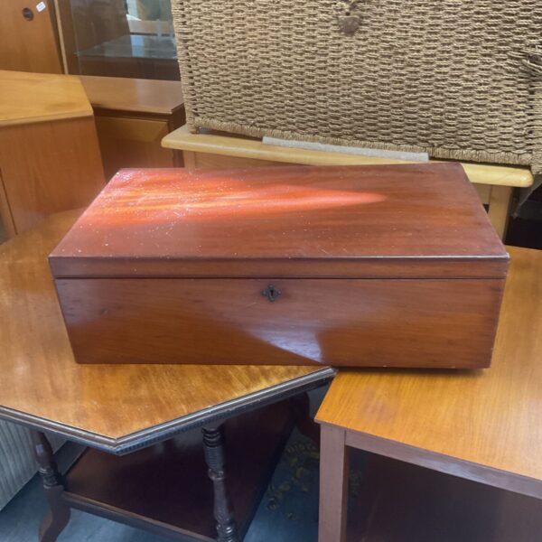 Antique mahogany cutlery box on a table.