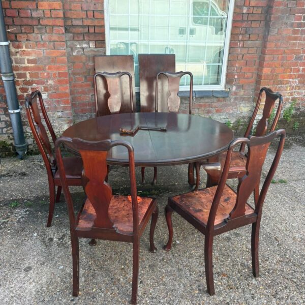 Antique mahogany extending dining table with six chairs in a dining room setting.