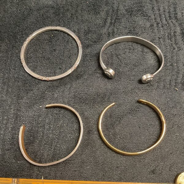 Lot of four silver-tone metal cuff bracelets.