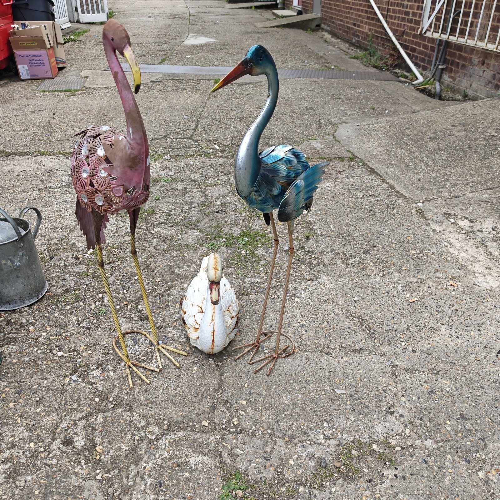 Metal garden flamingo and swan ornaments for outdoor decoration.