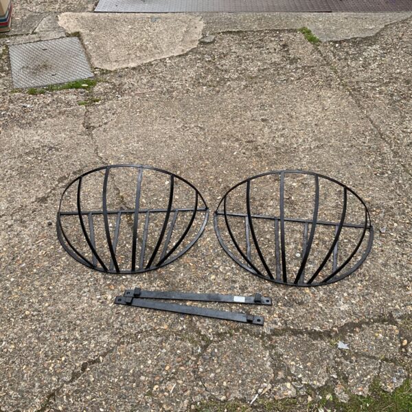 Pair of vintage metal hay mangers for livestock feeding.