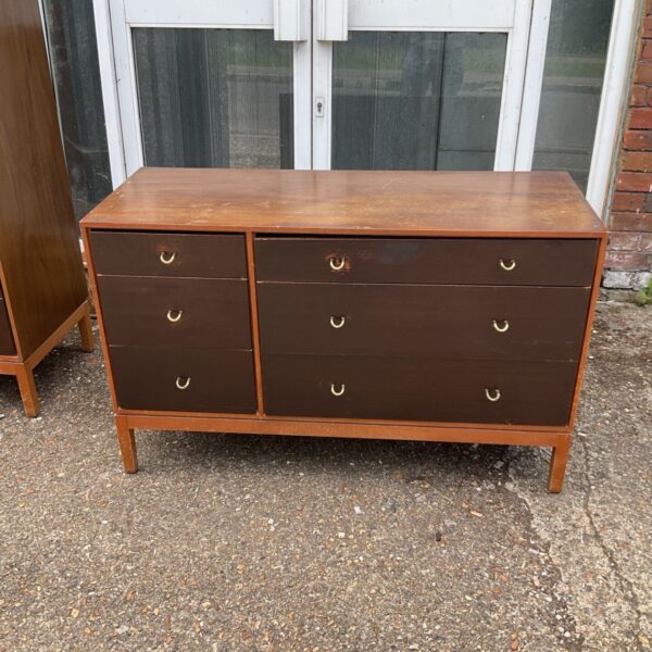 Vintage mid-century chest of drawers with curved pulls and tapered legs.
