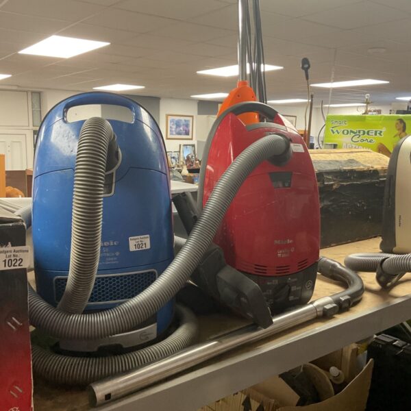 Blue and white Miele S6 hoover with hose attached.