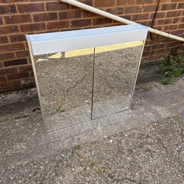 Mirrored bathroom cabinet with integrated strip light, ideal for storage.