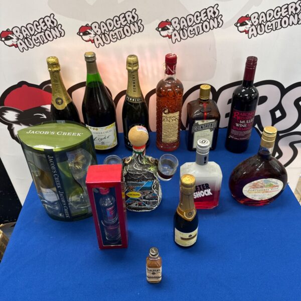 Mixed alcohol lot including whiskey, brandy, and wine bottles.