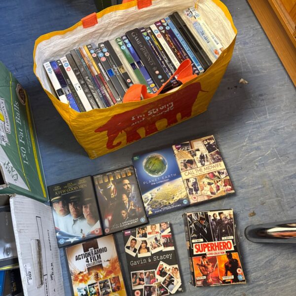Mixed DVD collection in a colourful bag, including movie and TV series titles.