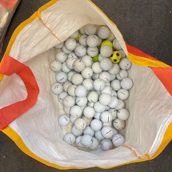 Mixed lot of used Nike and Callaway golf balls for practice.