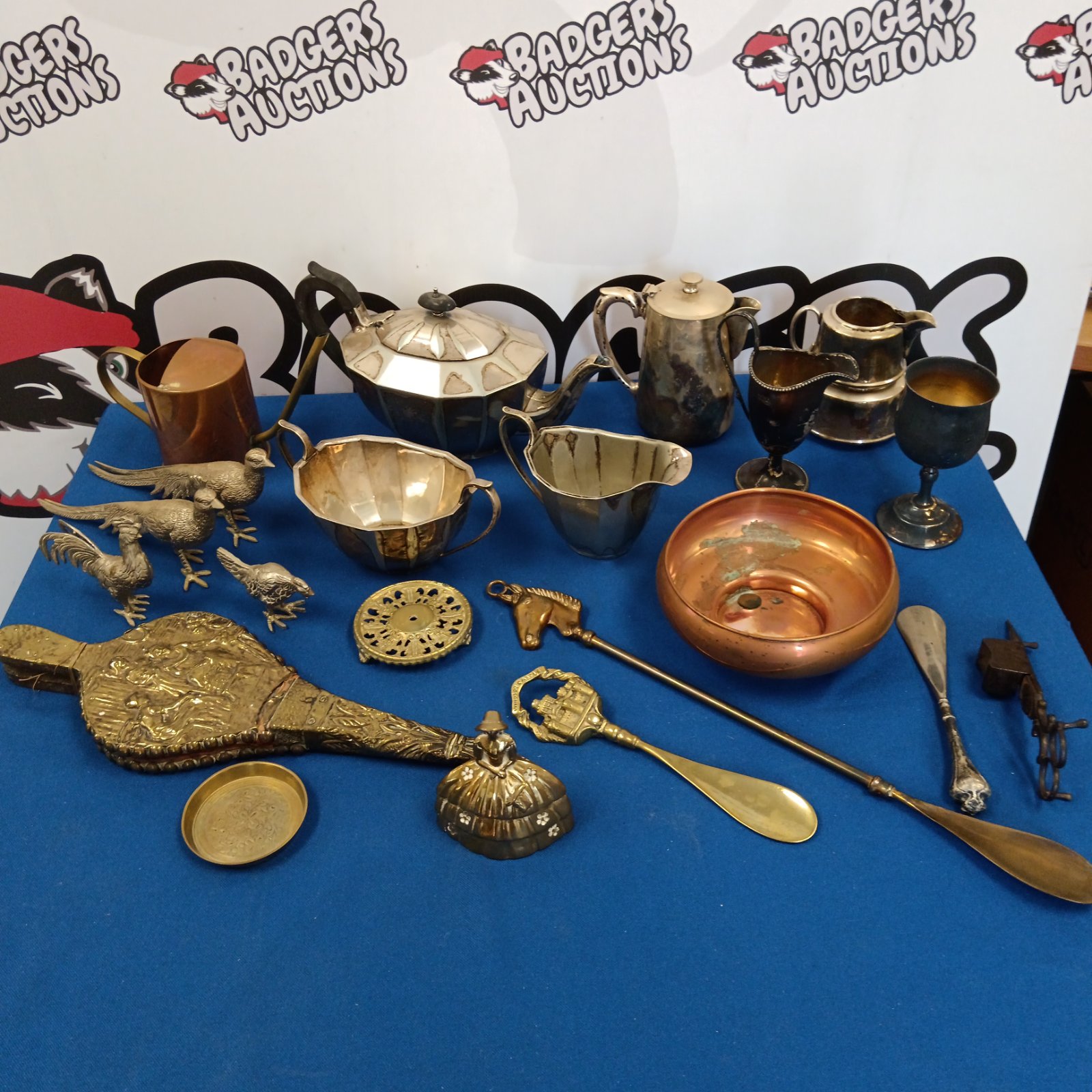 Mixed silver plate and copper lot with teapots and pheasant figurines.