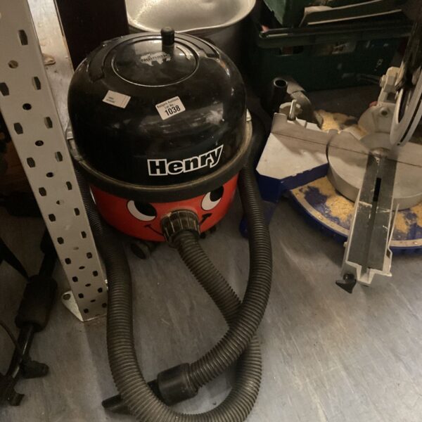 Red Numatic Henry Hoover with flexible hose.