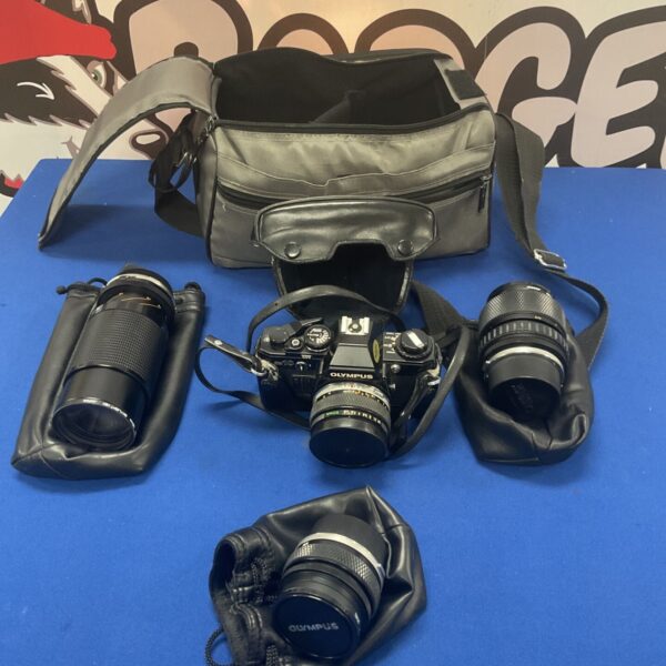Olympus OM10 camera kit with lenses and bag, vintage photography.