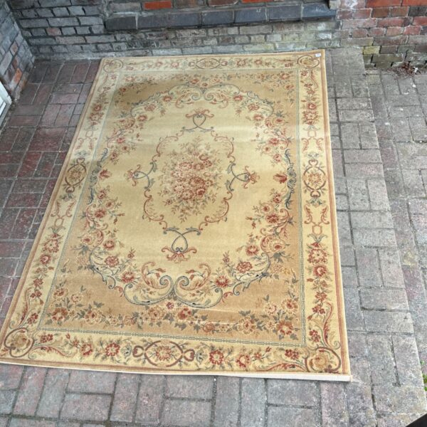 Gold and cream Oriental rug with a floral medallion design.