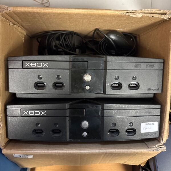 Pair of original Microsoft Xbox consoles with controllers for retro gaming.