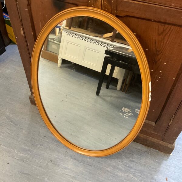 Vintage oval wooden framed mirror for wall decoration.