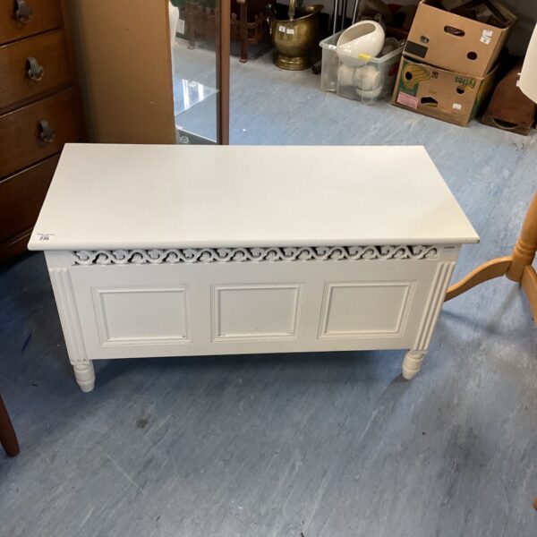 White painted storage chest with decorative detailing.