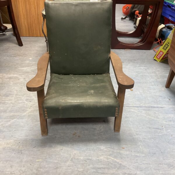 Vintage green vinyl Parker Knoll armchair in a room setting.