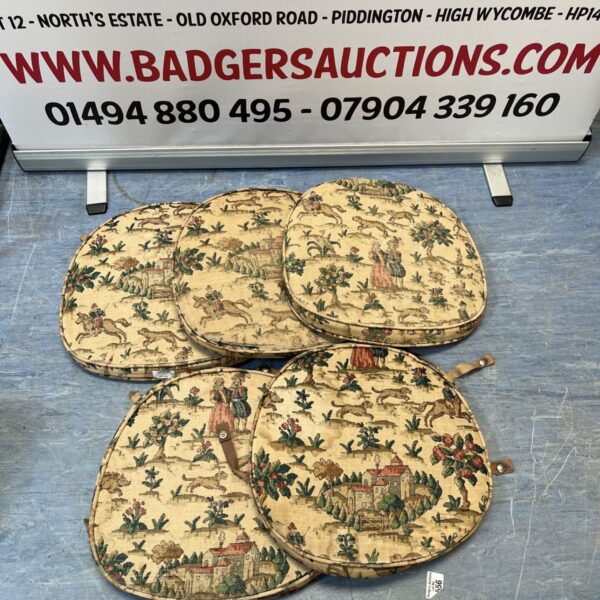 Set of five floral patio chair cushions for garden seating.