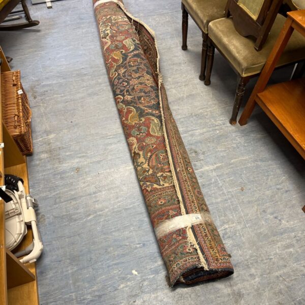 Intricate red and blue Persian style carpet with traditional patterns.