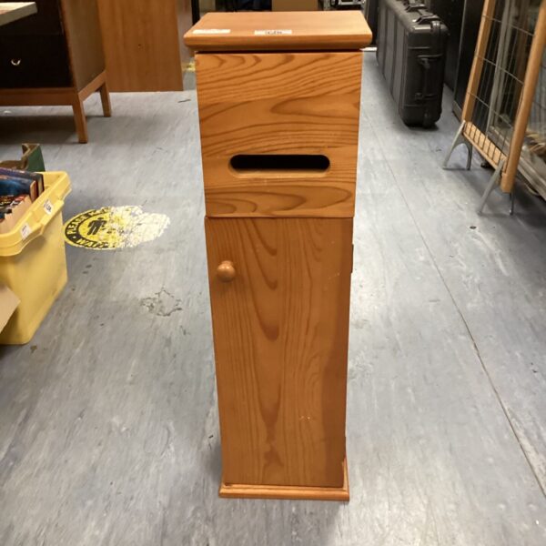 Vintage pine bathroom cabinet with a single door for storage.
