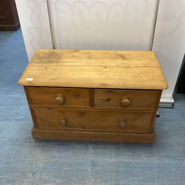 Vintage pine chest of drawers with three drawers and wooden knobs.